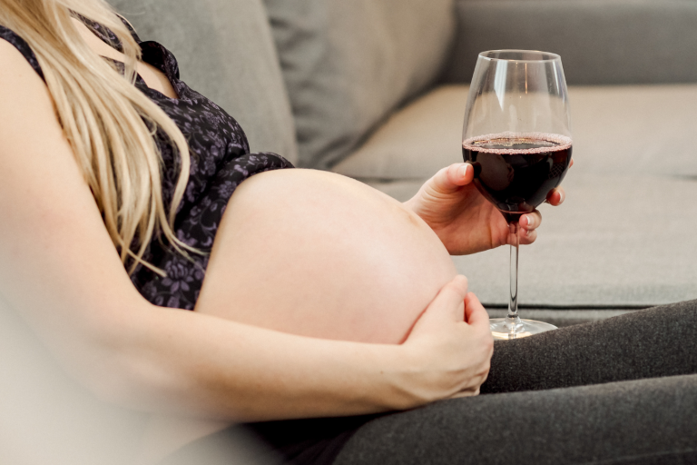 Pregnant woman holding wine glass