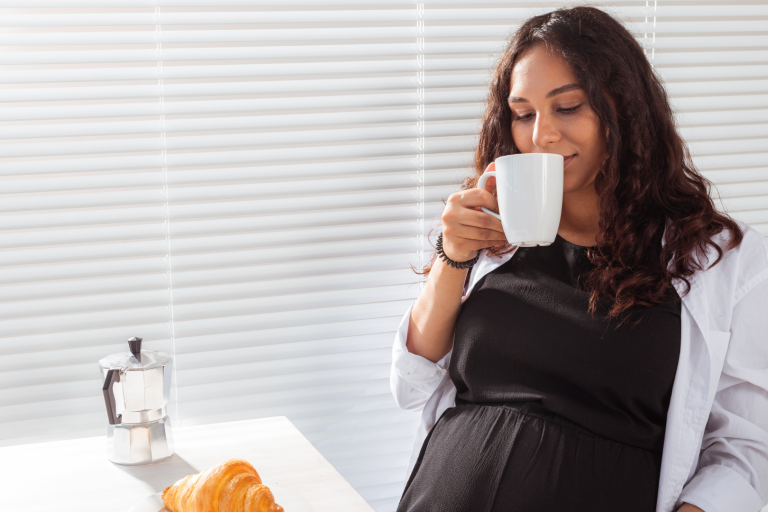 Pregnant lady having a cup of coffee