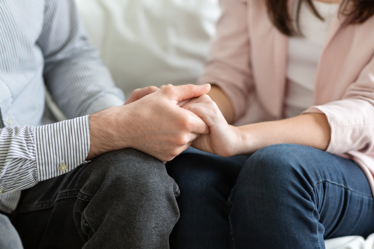 Couple sitting holding hands