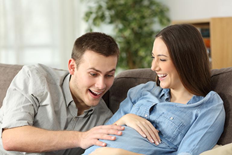 Couple touching pregnant lady tummy