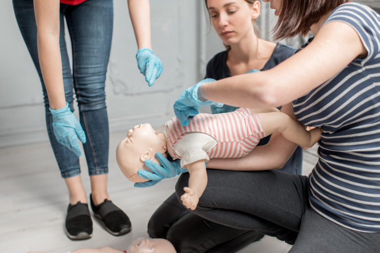 First aid course with instructor hold dummy baby