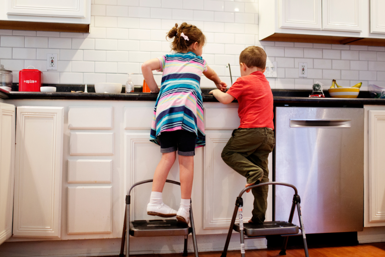 Children standing on steps in a kitchen