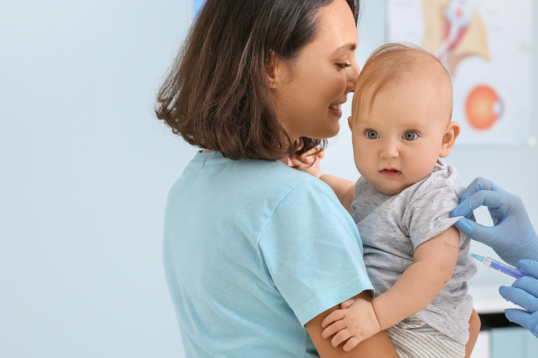 Mum holding baby getting vaccinated