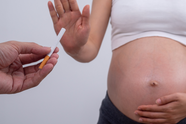 Pregnant woman being handed a cigarette