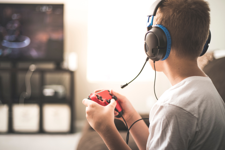 Teenager with headphones on holding a Gaming handset