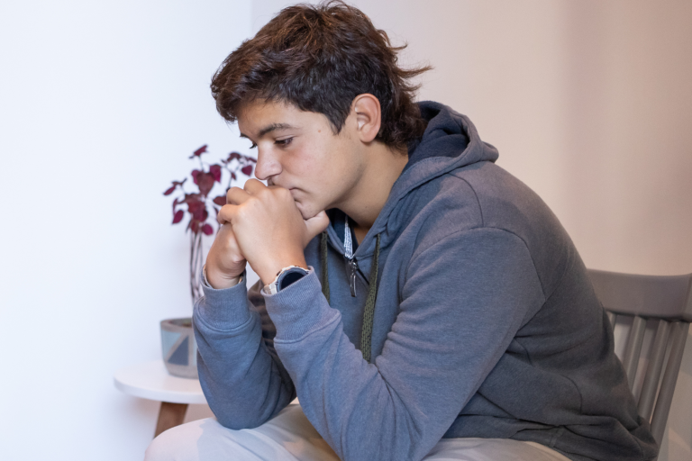 Teenage boy sitting contemplating