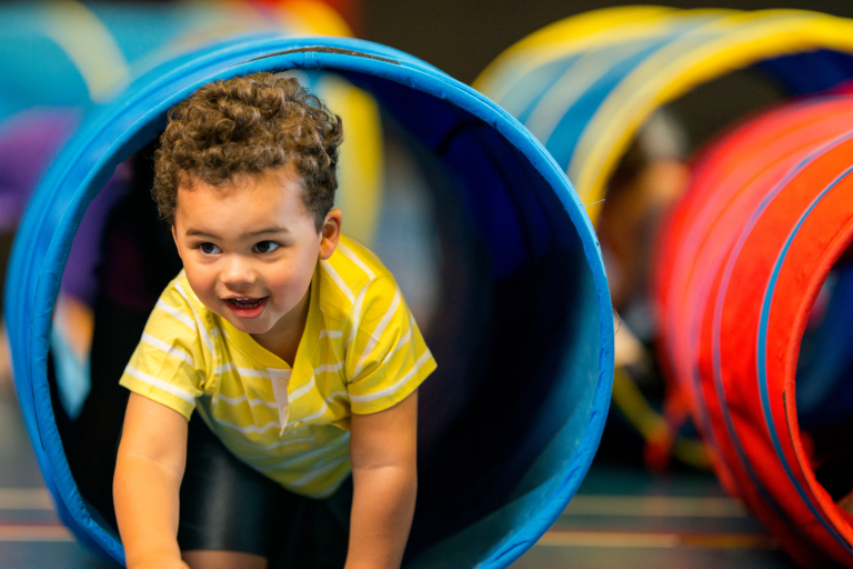 Toddler crawling through a play tunnel