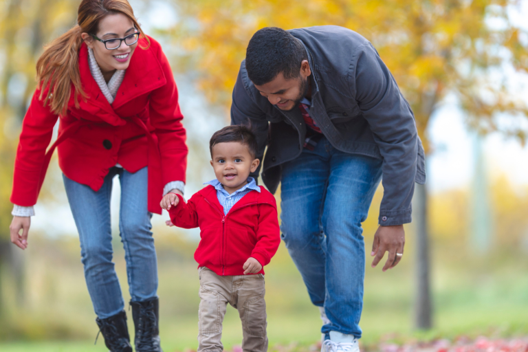 Parent walking in park with toddler