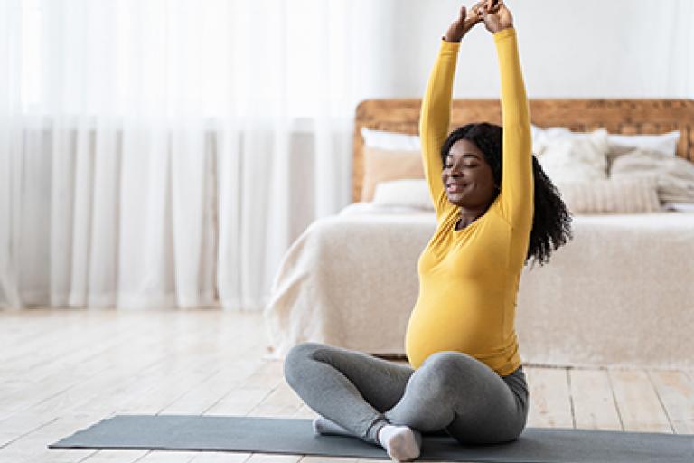 Pregnant lady on floor doing yoga