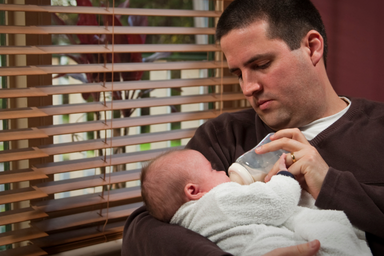 dad bottle feeding baby