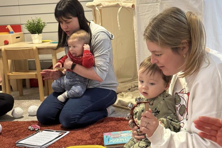 2 mums and their babies singing and playing instruments