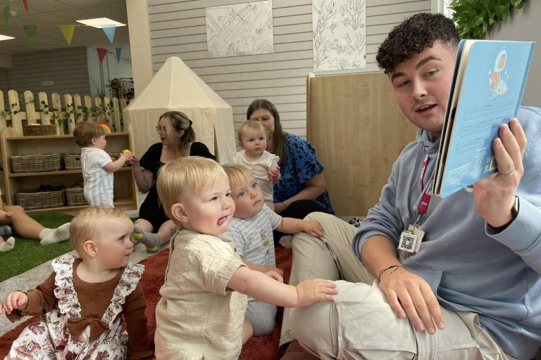 Adult reading a book to children