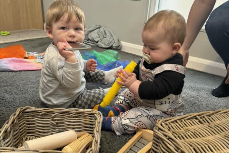 Two babies playing with instruments