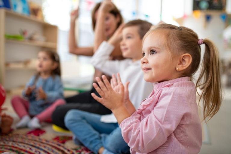 Children sat on the floor and clapping
