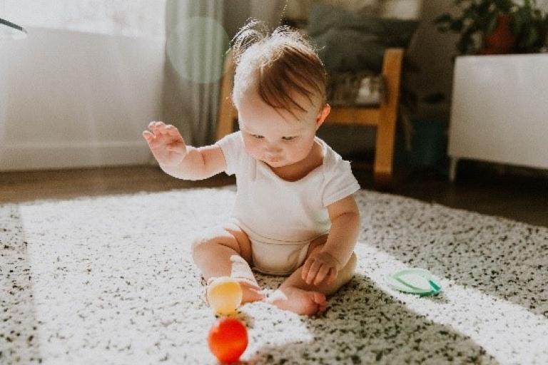 Baby sat on the floor playing with shapes