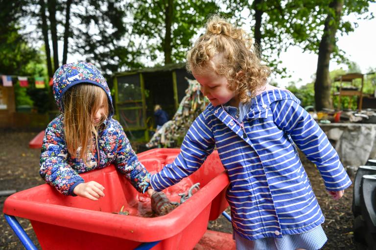 Two children playing outside with water