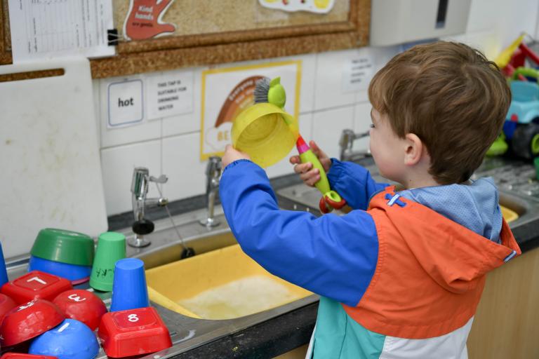 Child washing up at the sink