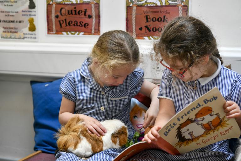 Two children sat reading a book together