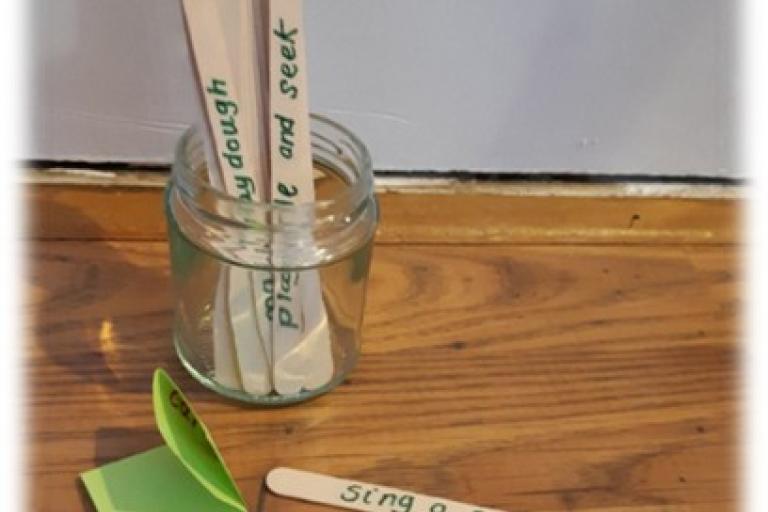 Lollipop sticks with writing inside an empty jar