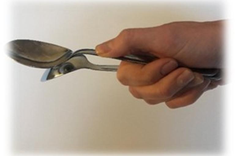 Holding two spoons tied together