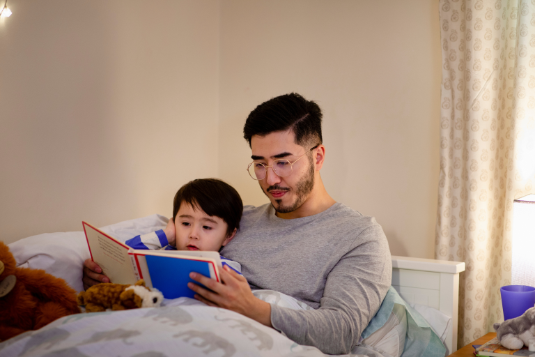 Adult reading child a story before bedtime