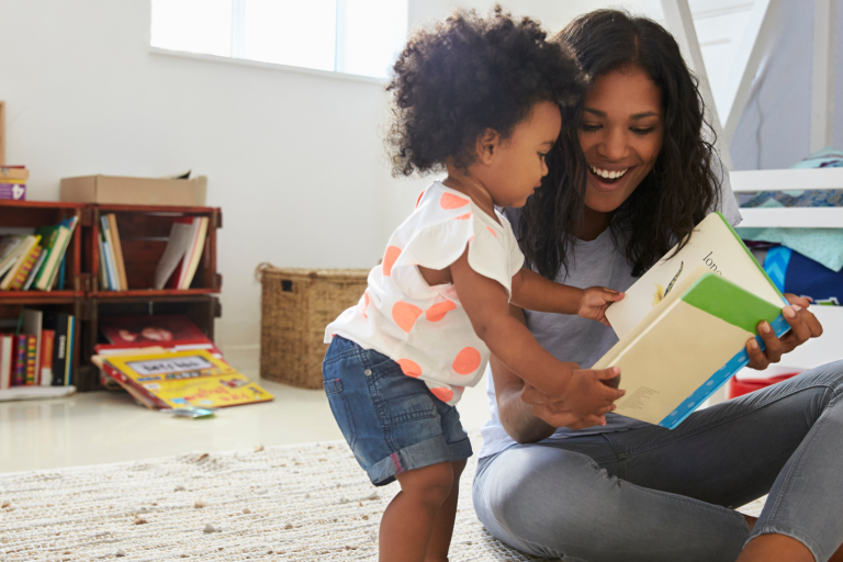 Adult and child looking at a book