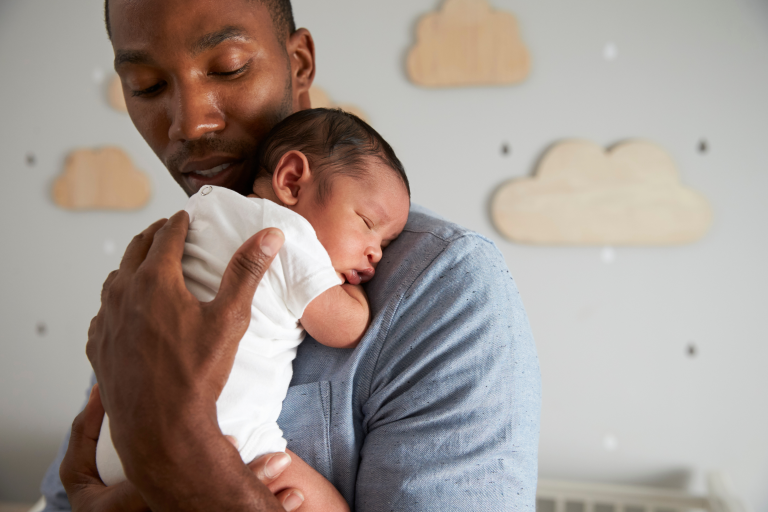 Adult holding a baby whilst standing and soothing