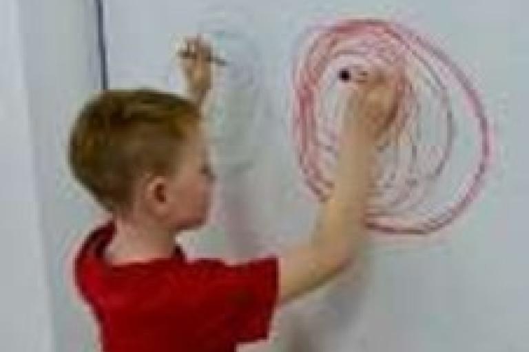 Child using both hands to draw