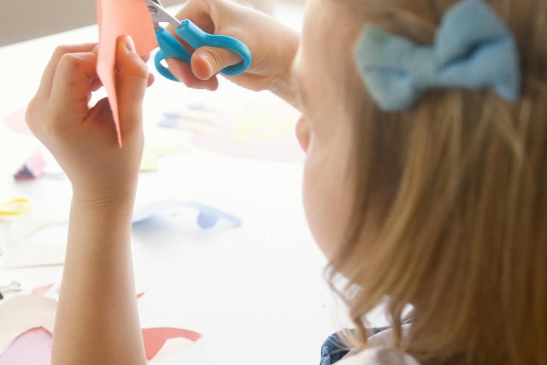 Child using scissors to cut paper