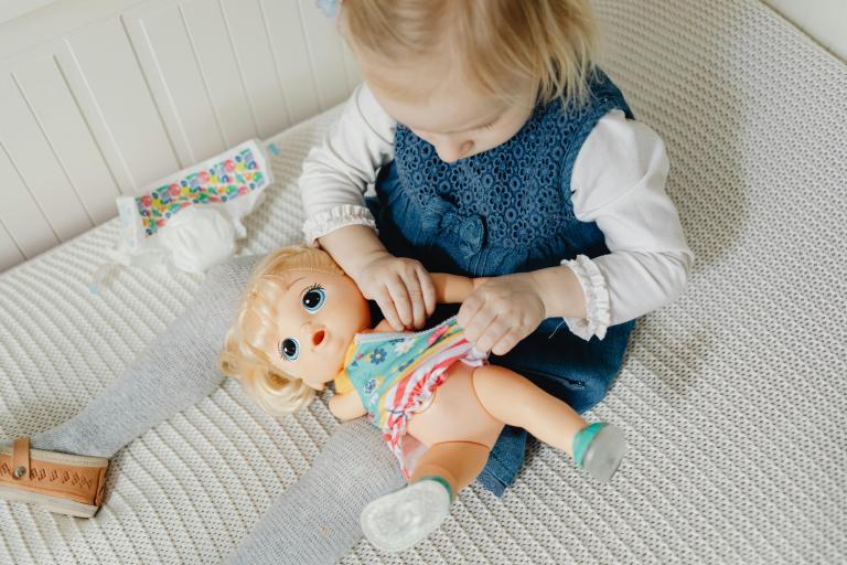 Child dressing a doll