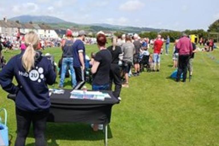 Group of adults, stood outside, looking towards the distance