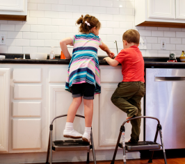 Children standing on steps in a kitchen