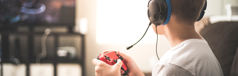 Teenager with headphones on holding a Gaming handset