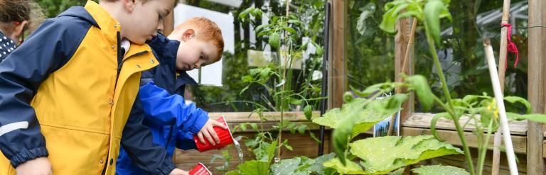 Two children watering plants