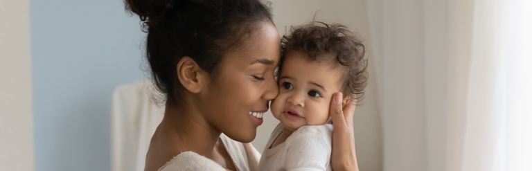 Parent holding a baby and smiling