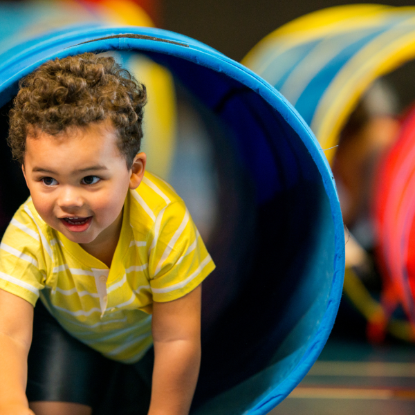 Toddler crawling through a play tunnel