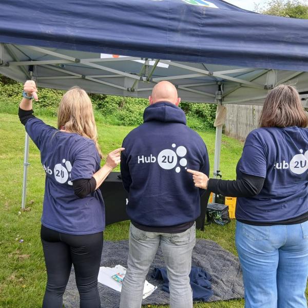 Three adults with Hub2U logo clothing